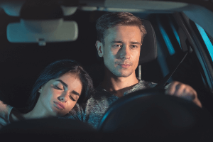 tired couple in car at night