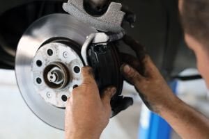 mechanic repairing car brakes