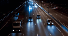 cars with headlights driving down road