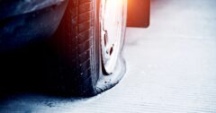 Close up of a flat tire on an old car.