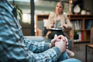 man sitting on couch in therapist's office